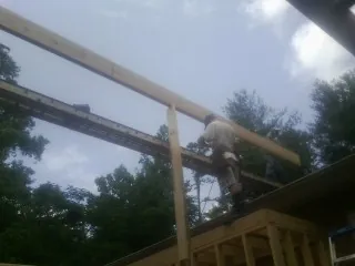 Carpenter setting a ridge beam over a new addition frame — Ice Dam Removal by Roofing Brothers in Wake Forest