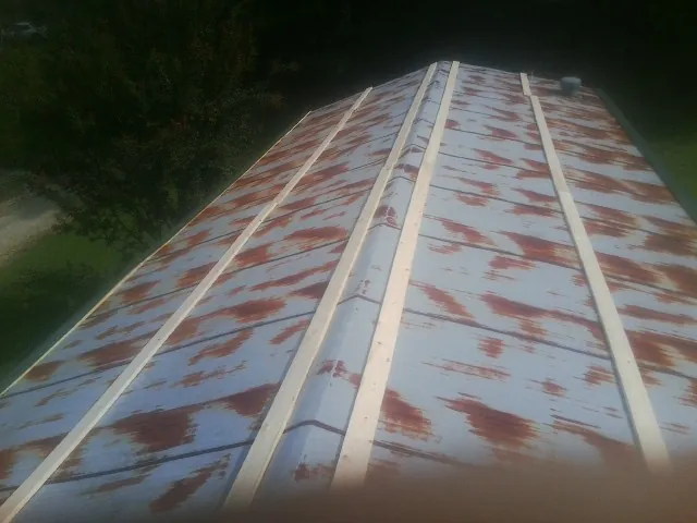 Rusted metal roof panels with new wood purlins before replacement — Storm Damage Roof Repair in Wake Forest by Roofing Brothers
