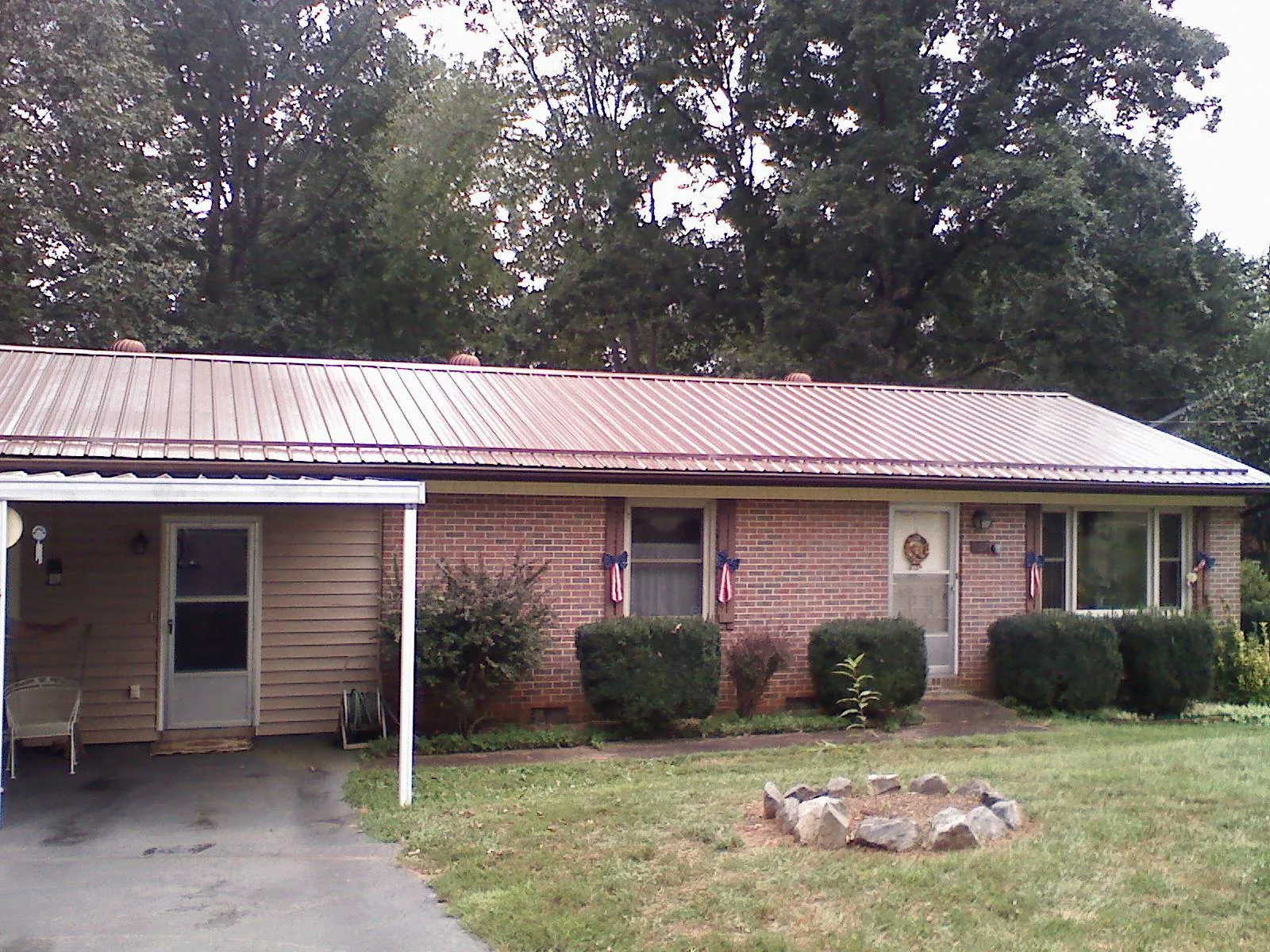 Bronze metal roof and carport on a brick ranch home — Roof Repair work by our crew in Wake Forest