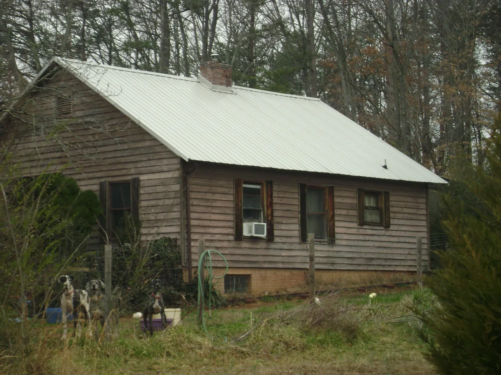 White metal roof on an old wood sided farmhouse, from a Metal Roof Installation job in Wake Forest